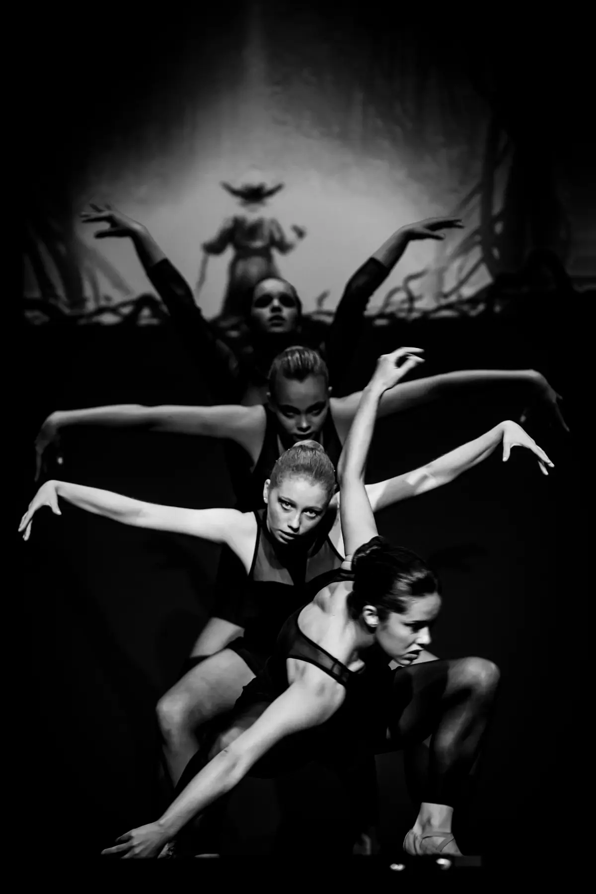 En blanco y negro, cuatro bailarinas encadenan una figura.