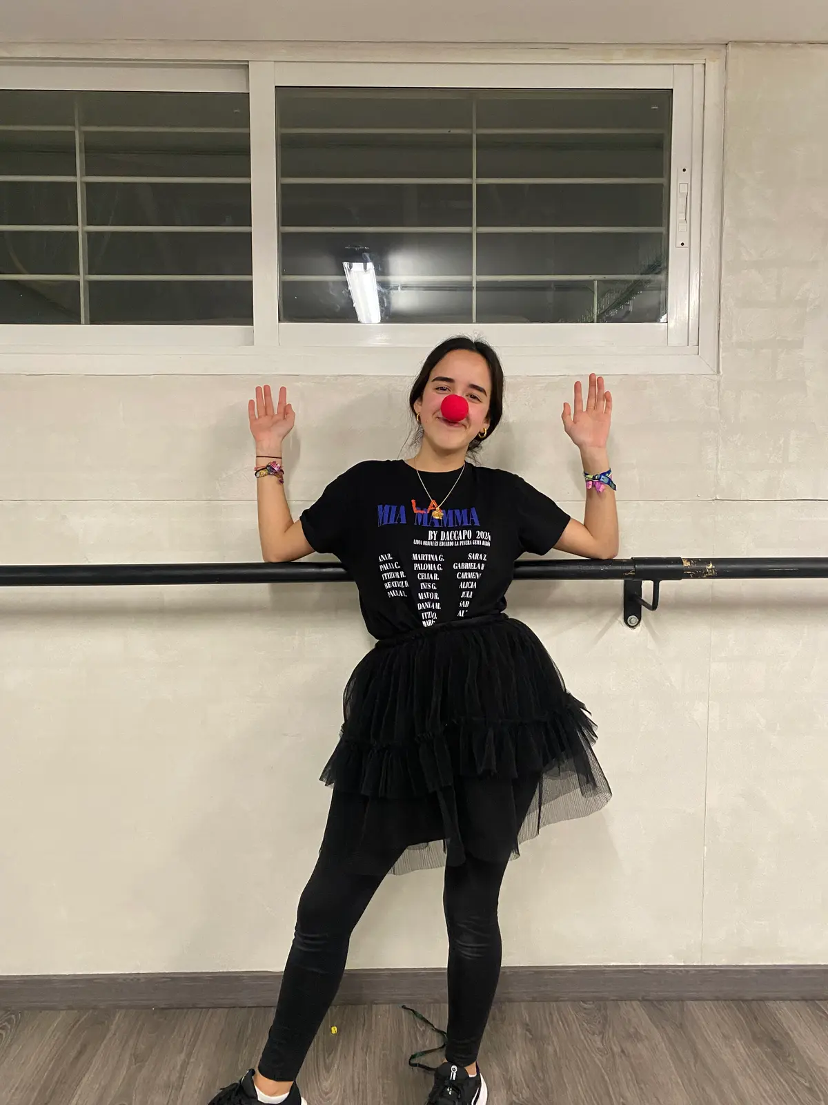 Una alumna con nariz de payaso posa junto a la barra de la sala.