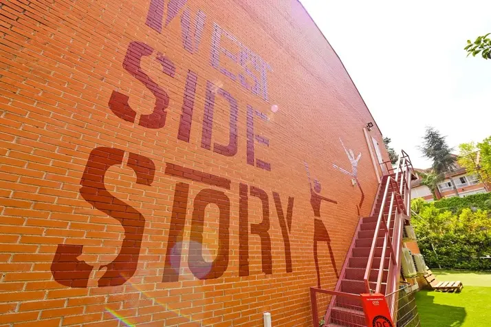 Pared de ladrillo con el mural de West Side Story y la escalera exterior.