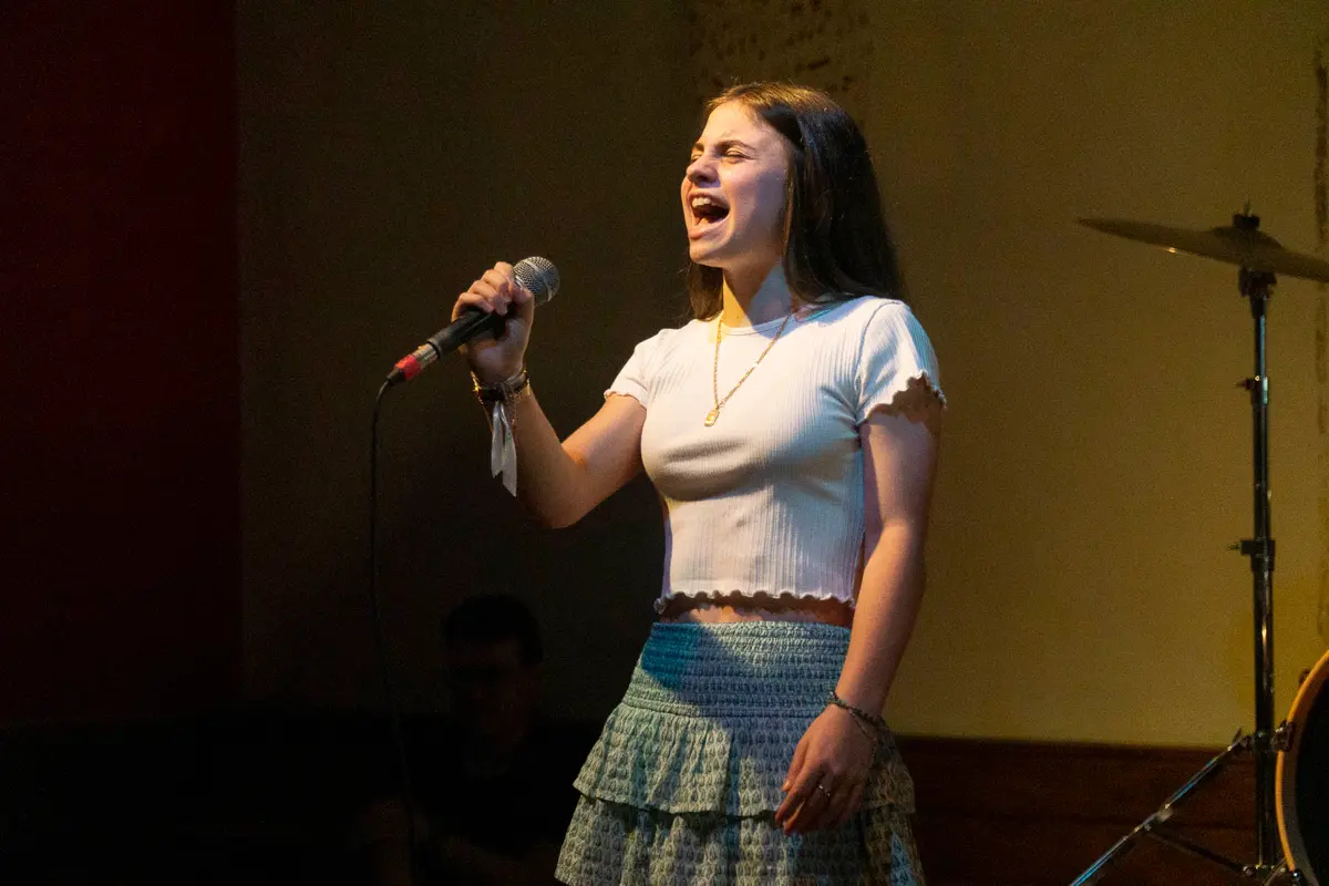 Una alumna canta con micrófono.