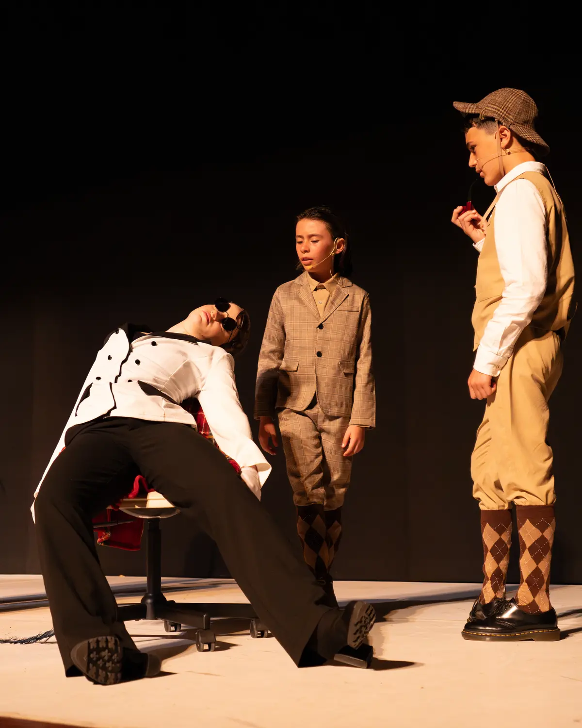 Tres intérpretes con vestuario de época en mitad de una escena.