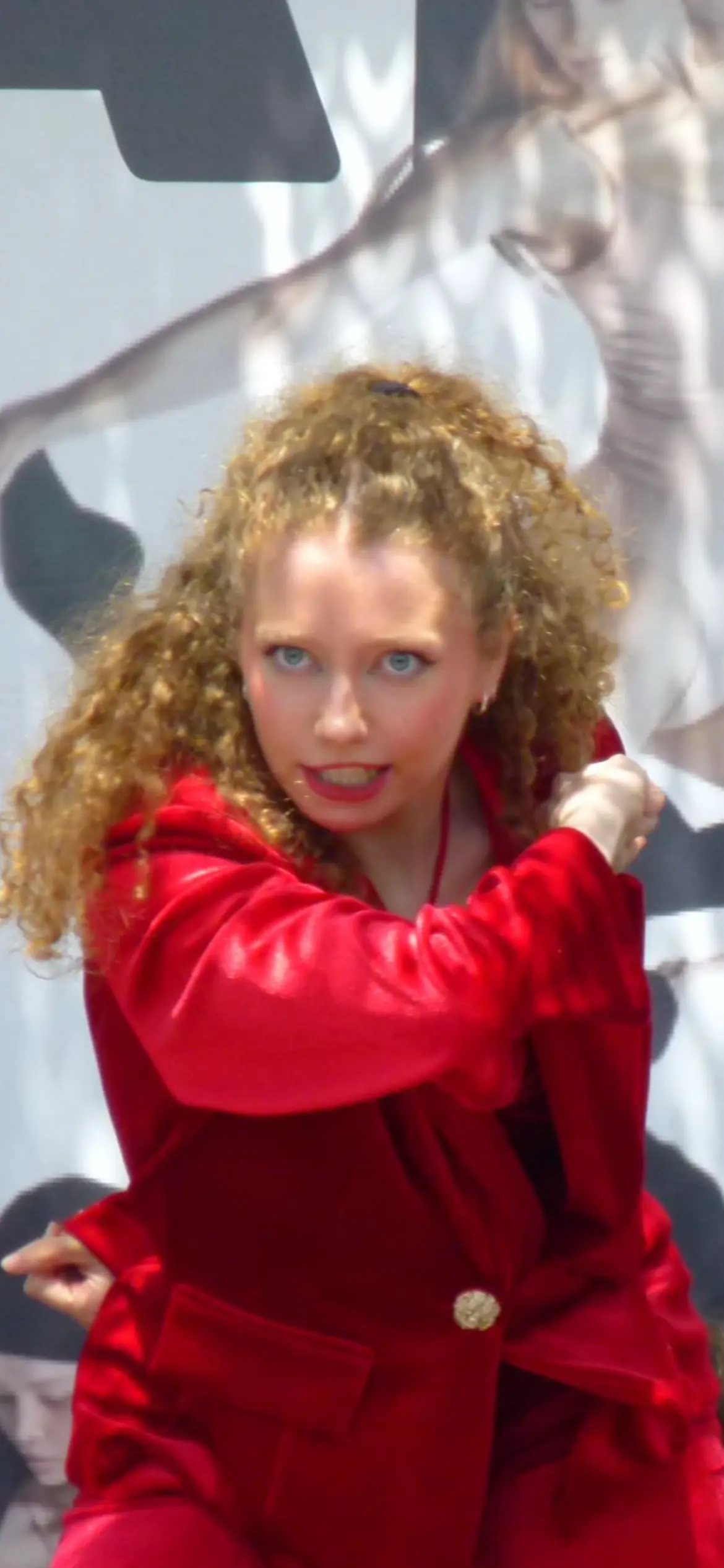 Una intérprete de pelo rizado y traje rojo en plena coreografía.